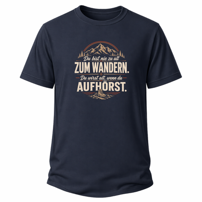 Navy blaues Wander-T-Shirt mit Spruch „Du bist nie zu alt zum Wandern. Du wirst alt, wenn du aufhörst.“, Bergmotiv, Wald und Wanderschuh.