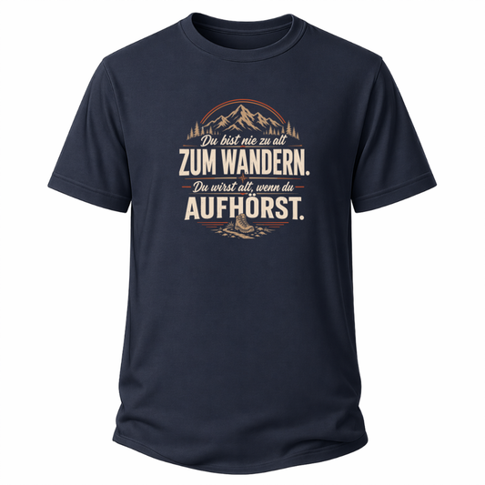Navy blaues Wander-T-Shirt mit Spruch „Du bist nie zu alt zum Wandern. Du wirst alt, wenn du aufhörst.“, Bergmotiv, Wald und Wanderschuh.