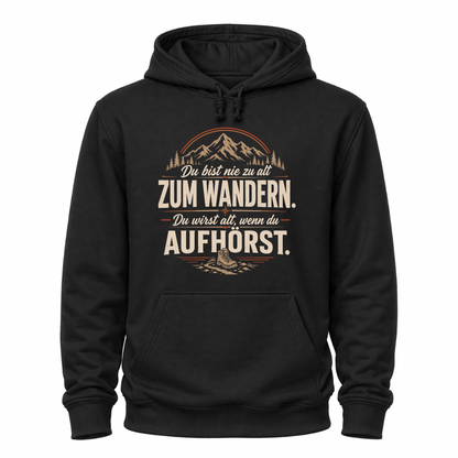 Schwarzes Wander-Hoodie mit Spruch „Du bist nie zu alt zum Wandern. Du wirst alt, wenn du aufhörst.“, Bergmotiv, Wald und Wanderschuh.